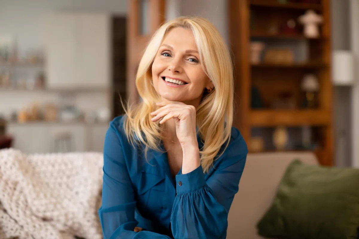 Pacientă blondă zâmbind, pachetul premium Implant Platinum Ceramic la Clinica 32